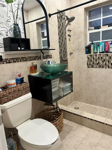 a bathroom with a sink a toilet and shower