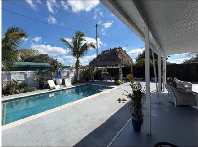 a swimming pool with outdoor seating and yard