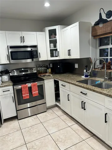 a kitchen with appliances a sink and cabinets