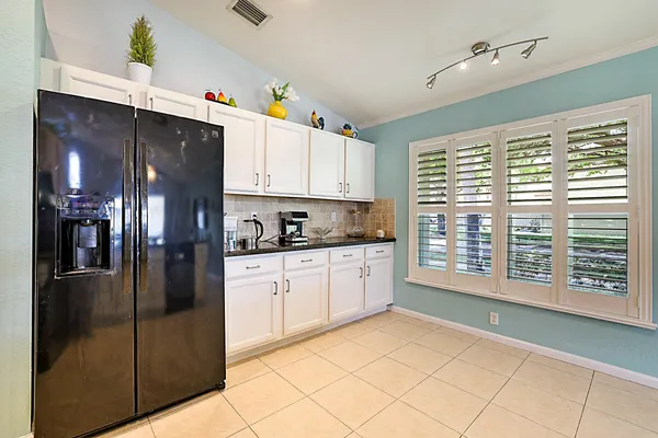 a living room with furniture a flat screen tv and kitchen view