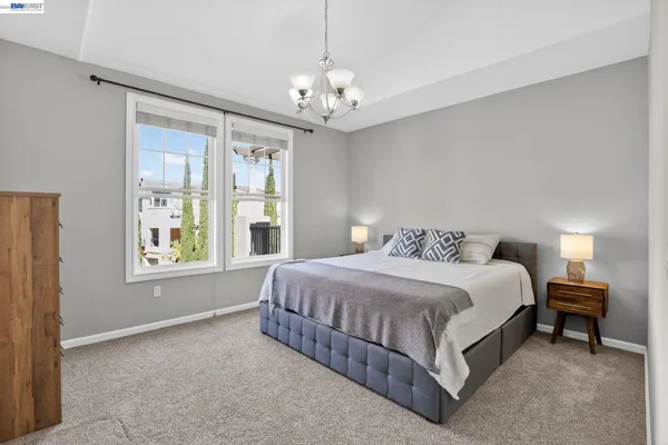 a spacious bedroom with a bed and a chandelier