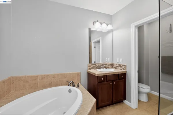 a bathroom with a tub sink and mirror