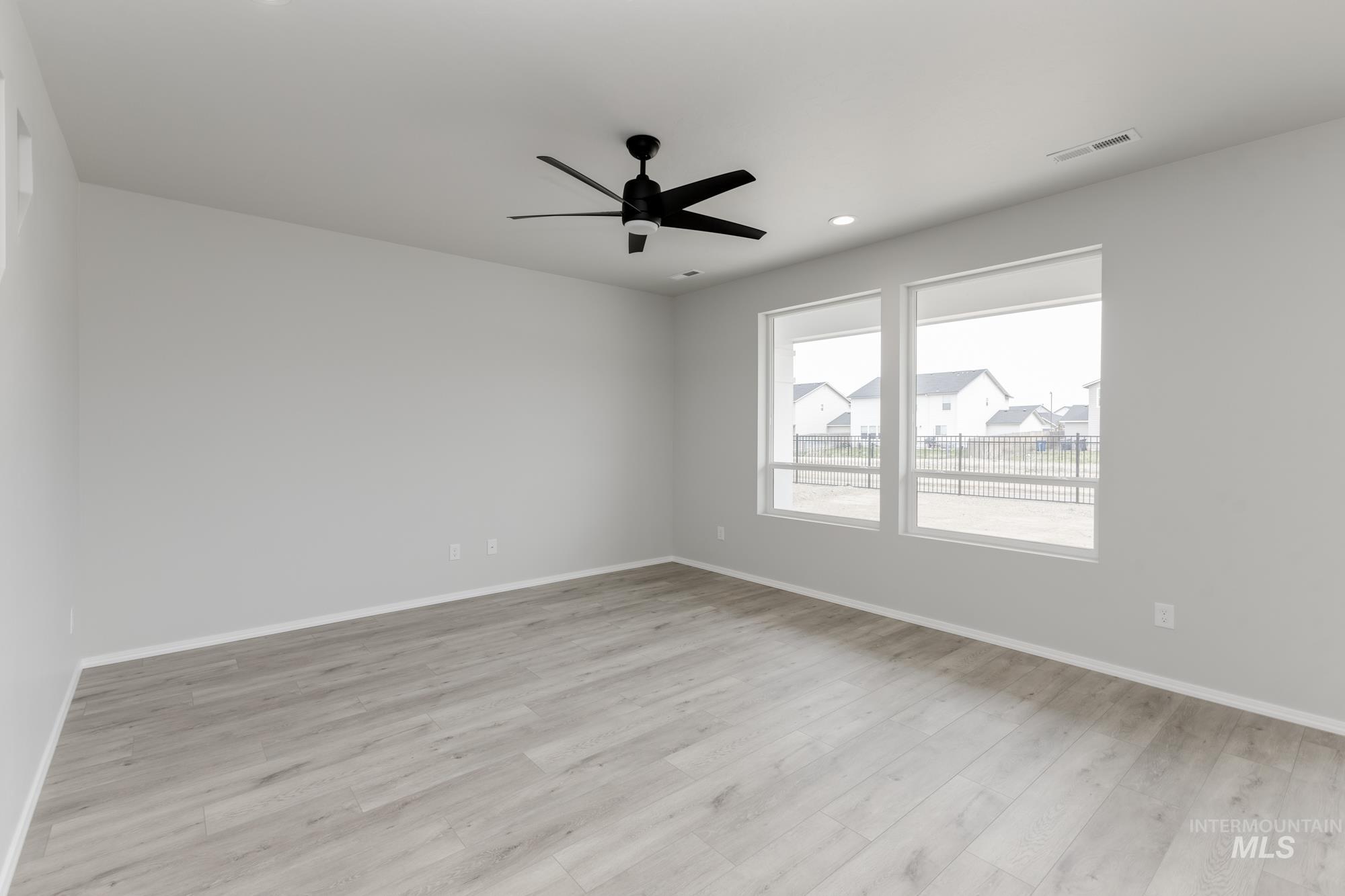 12842 Ropers Street Nampa, ID 83651 - Photo 9 of 29 Spacious room featuring wood-finish flooring, light grey walls, and a contemporary ceiling fan