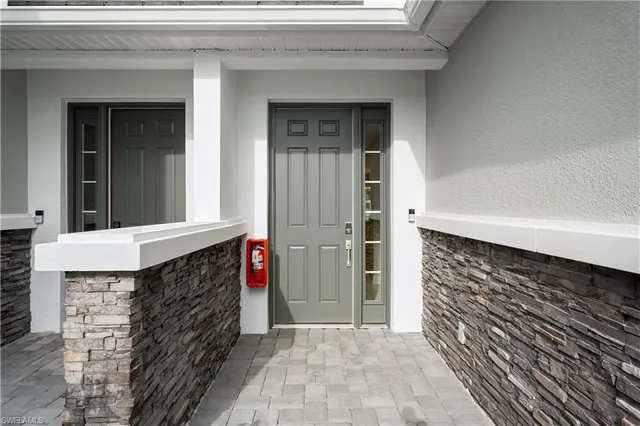 a kitchen with stainless steel appliances kitchen island granite countertop a stove a sink a refrigerator and white cabinets with wooden floor