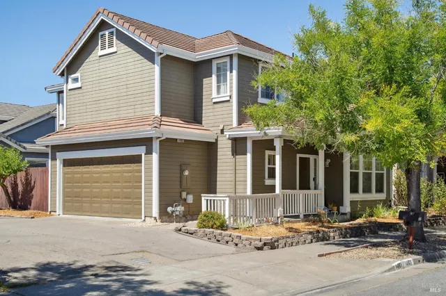 a front view of a house with garden and parking