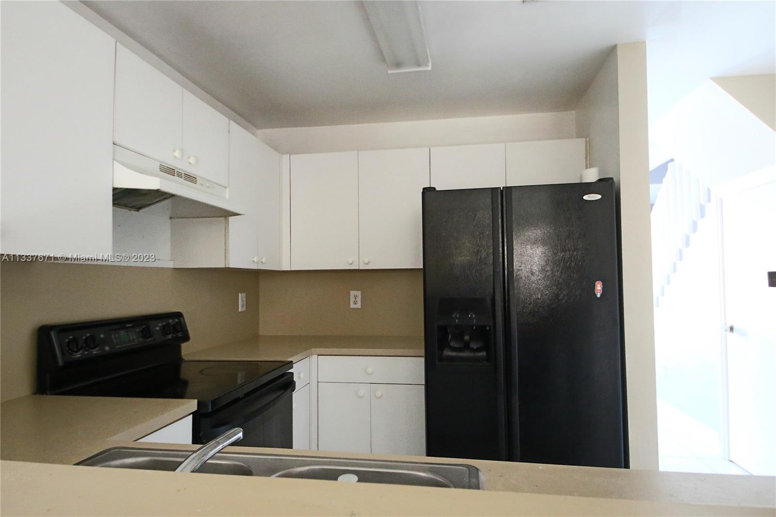 655 West 68th Street, Unit 10 Hialeah, FL 33014 - Photo 6 of 19 a kitchen with a refrigerator and cabinets