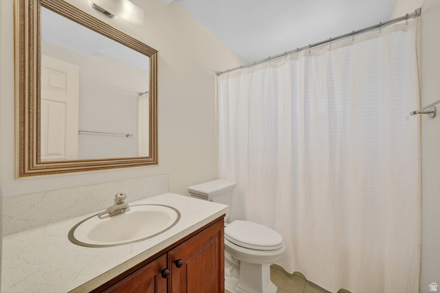 3120 North Apache Way Provo, UT 84604 - Photo 45 of 58 Bathroom featuring a wood-finish vanity with a light-toned countertop, an undermount sink, and a framed mirror