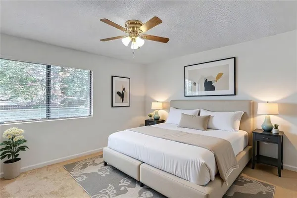 a bedroom with a large bed and a chandelier