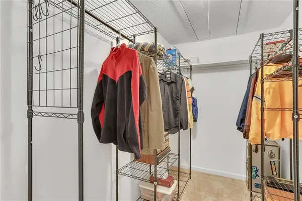a view of walk in closet with clothes and shoes