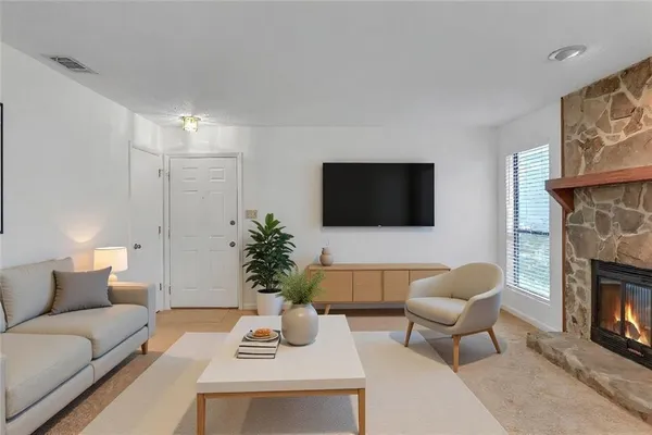 a living room with furniture a fireplace and a flat screen tv