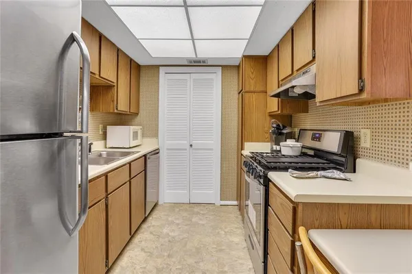 a kitchen with stainless steel appliances granite countertop a sink stove and refrigerator