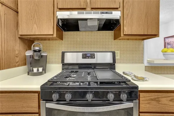 a stove top oven sitting inside of a kitchen