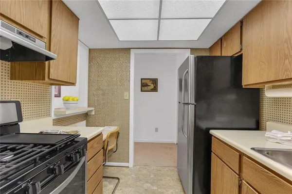 a kitchen with stainless steel appliances granite countertop a refrigerator and a stove