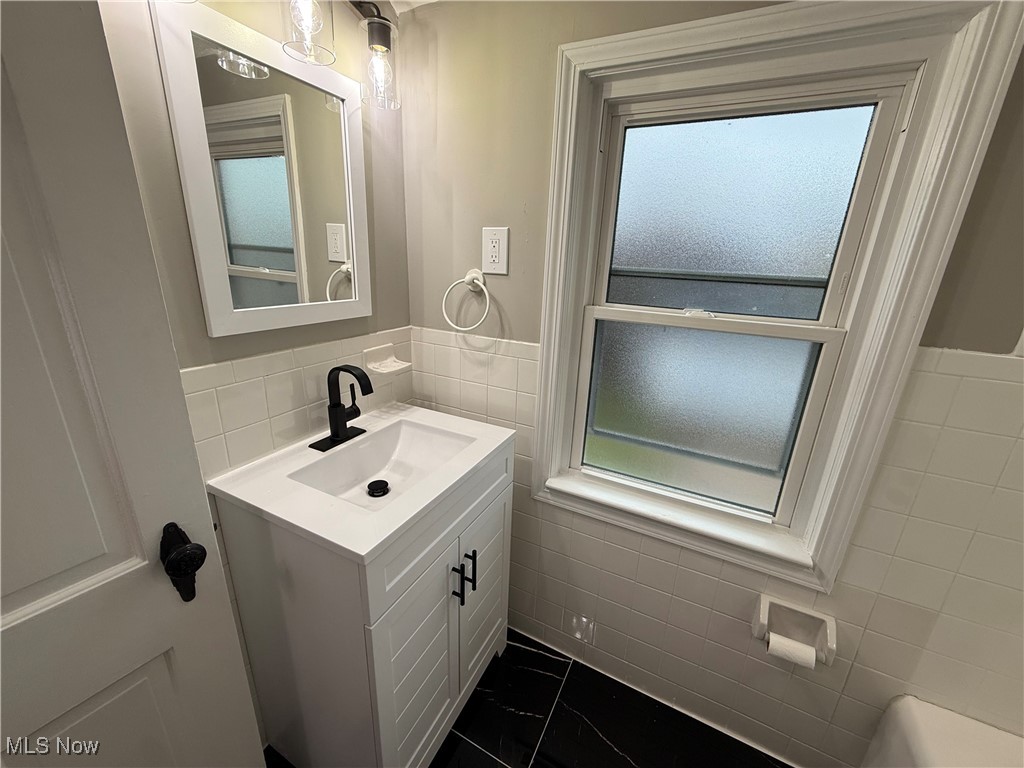 6807 Gerald Avenue Parma, OH 44129 - Photo 14 of 25 Bathroom with vanity, tile walls, and marble finish floor