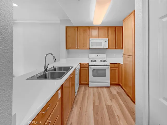 a kitchen with a sink a stove top oven and cabinetry