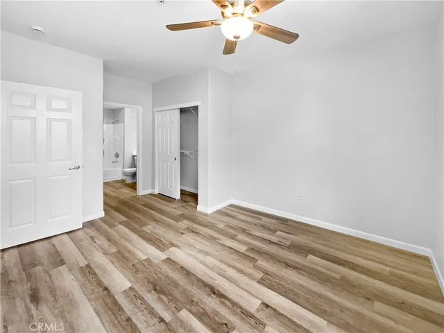 a view of a livingroom with wooden floor and a ceiling fan