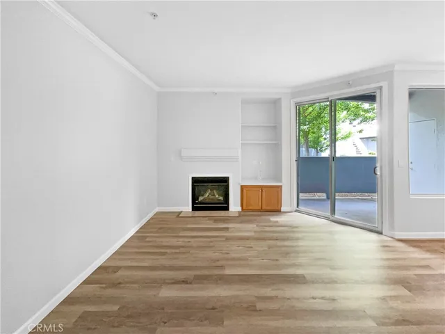 a view of an empty room with a fireplace and a window