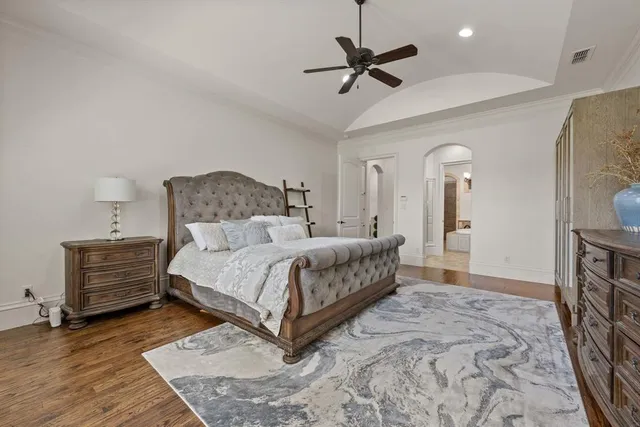 a bedroom with a bed chandelier and a rug