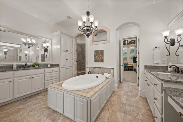 a spacious bathroom with a granite countertop sink a large mirror and a bathtub