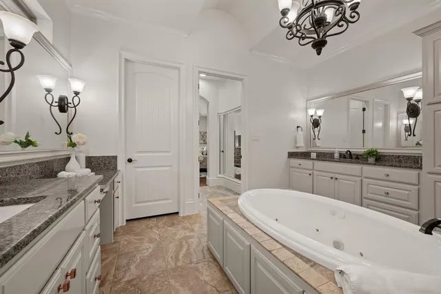 a spacious bathroom with a granite countertop sink a mirror a bathtub and shower