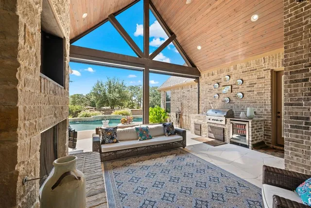 a living room with furniture a fireplace and large windows