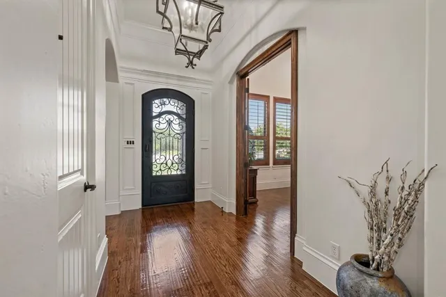 a view of a hallway to front door with wooden floor