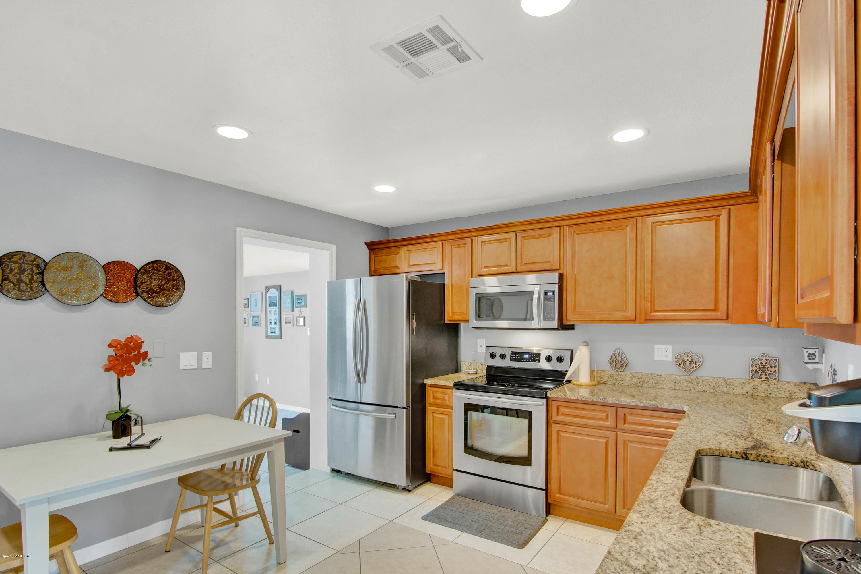 2512 Post Road Melbourne, FL 32935 - Photo 13 of 25 a kitchen with stainless steel appliances white cabinets a refrigerator and a stove top oven
