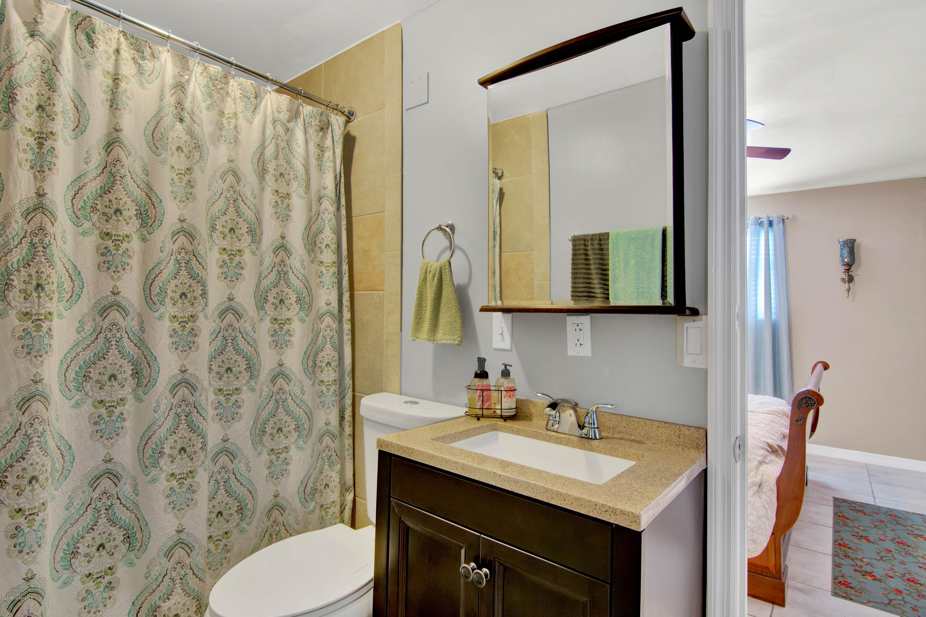 2512 Post Road Melbourne, FL 32935 - Photo 17 of 25 a bathroom with a granite countertop sink and a mirror