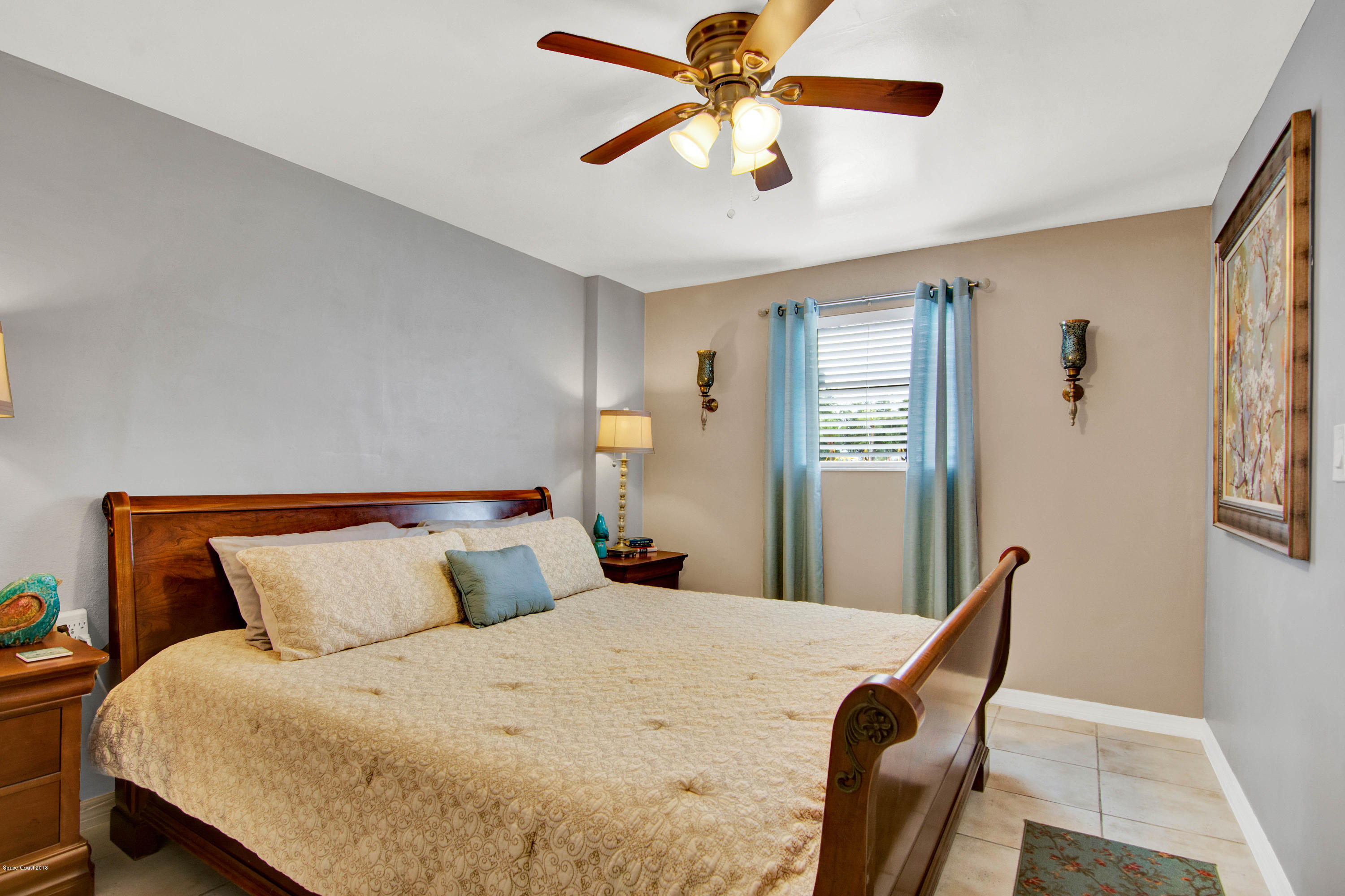2512 Post Road Melbourne, FL 32935 - Photo 18 of 25 a bedroom with a bed and a chandelier