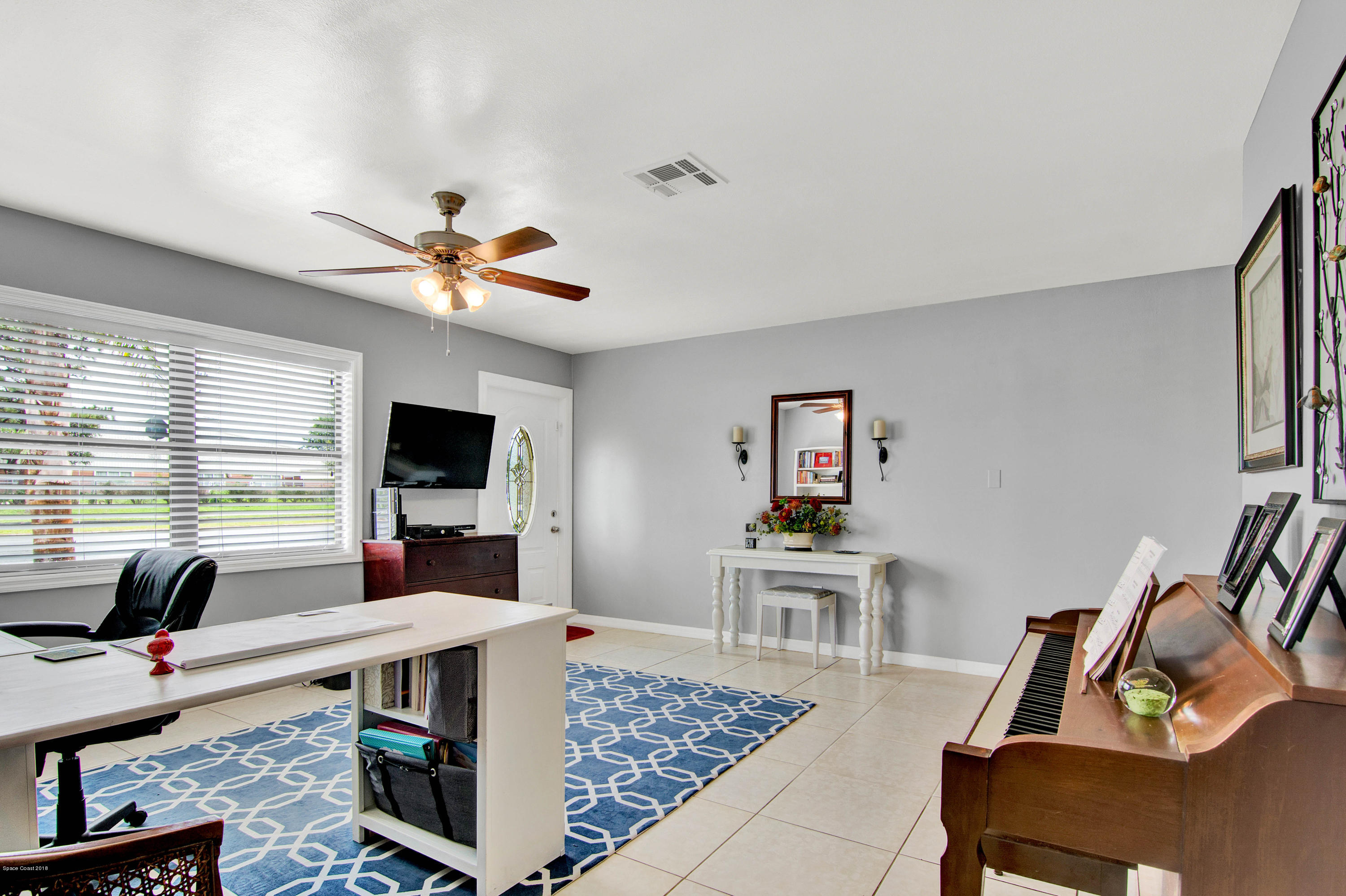 2512 Post Road Melbourne, FL 32935 - Photo 5 of 25 a work room with furniture a flat screen tv and a window