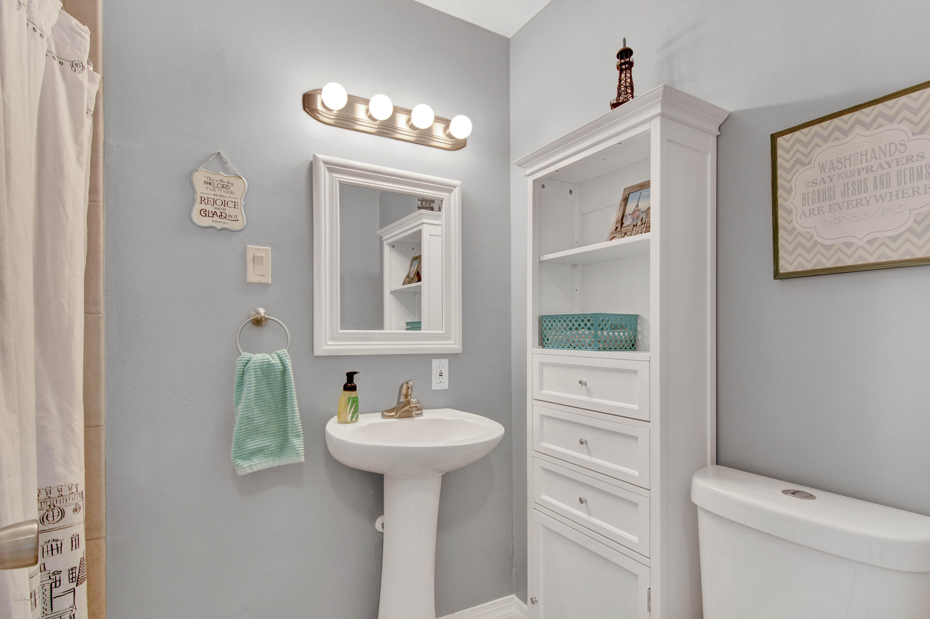2512 Post Road Melbourne, FL 32935 - Photo 6 of 25 a bathroom with a sink a toilet and a mirror
