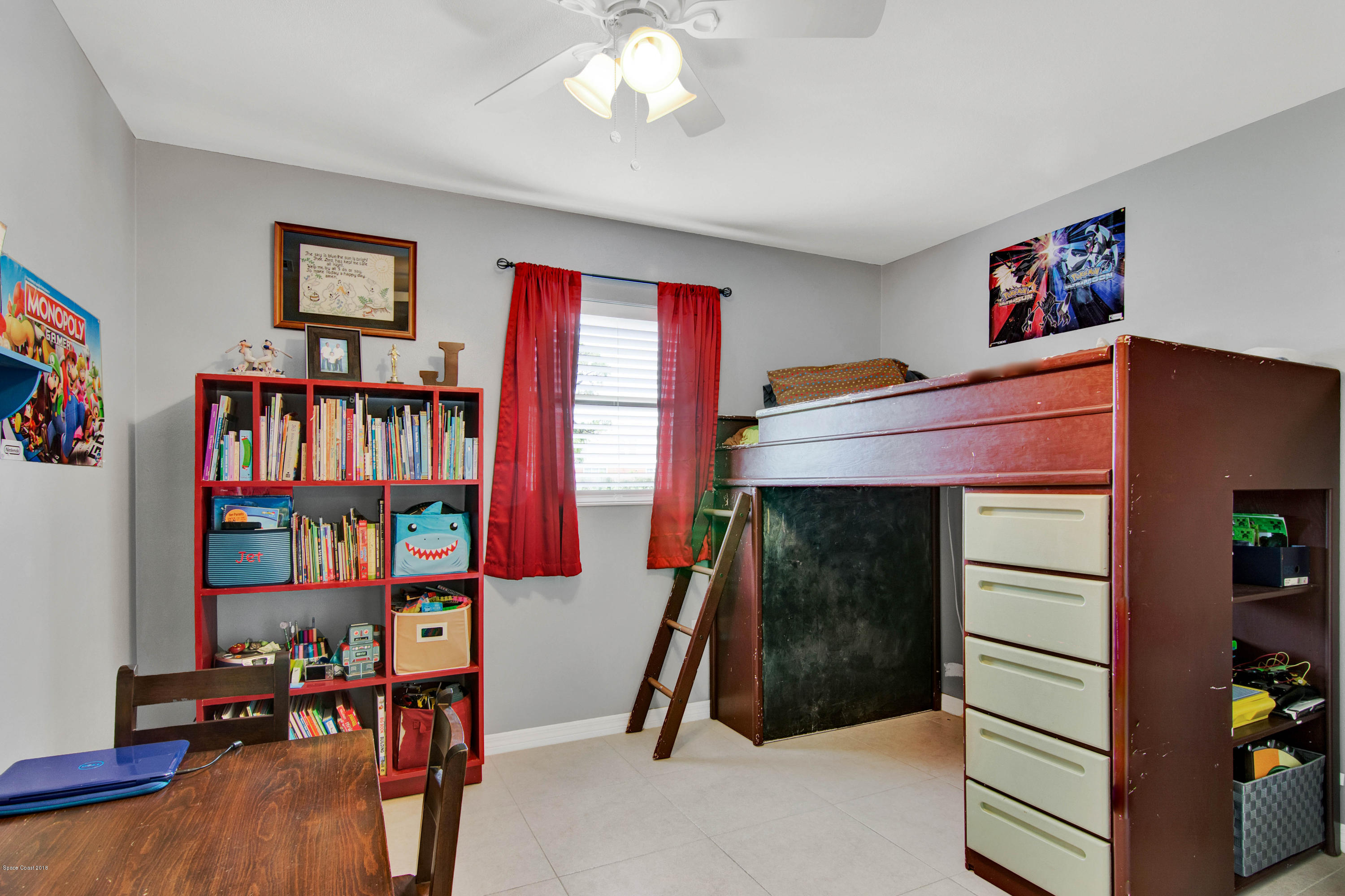 2512 Post Road Melbourne, FL 32935 - Photo 7 of 25 a bed room with a bed and a book shelf