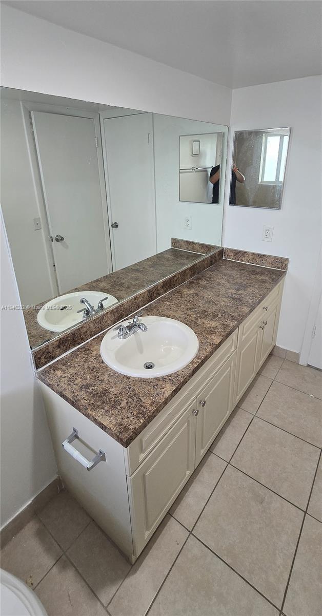 10820 Southwest 200th Drive, Unit 159 Cutler Bay, FL 33157 - Photo 11 of 17 a bathroom with a granite countertop sink and a mirror