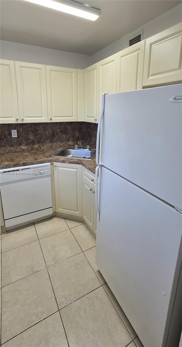 10820 Southwest 200th Drive, Unit 159 Cutler Bay, FL 33157 - Photo 2 of 17 a kitchen with a refrigerator and cabinets