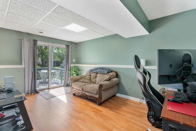 a living room with furniture gym equipment and a large window