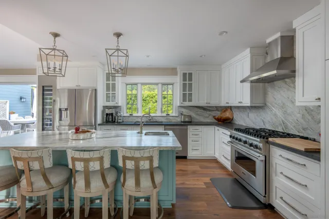 a kitchen with stainless steel appliances granite countertop a stove and chairs