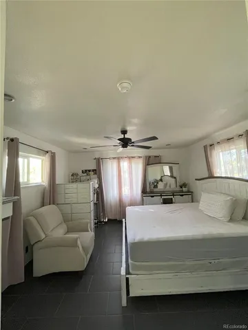 a bedroom with a bed a couch and window