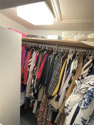a view of walk in closet with clothes and shoes