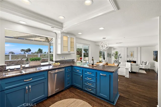a kitchen with granite countertop a sink dishwasher stove and wooden cabinets