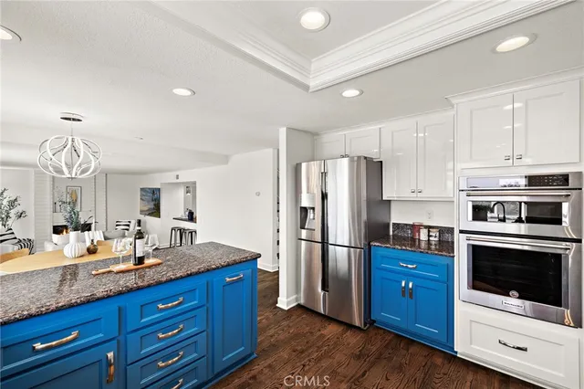 a kitchen with stainless steel appliances granite countertop a refrigerator a stove a sink and a microwave