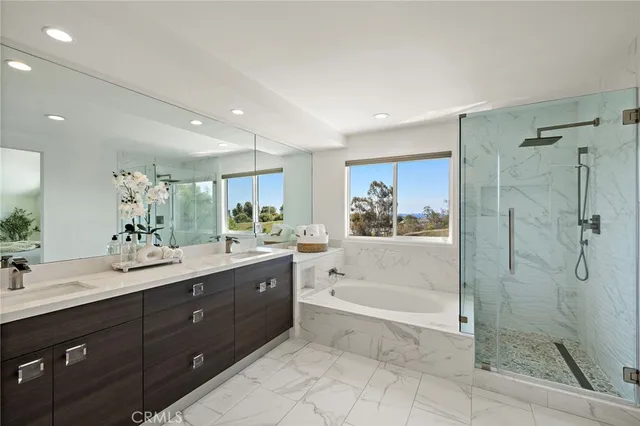 a spacious bathroom with a shower a sink and mirror with bathtub