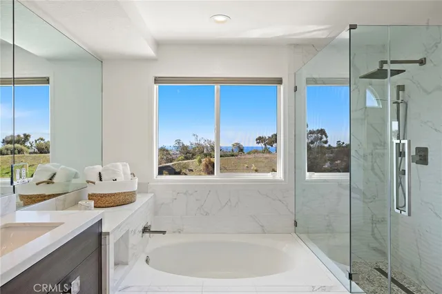 a bathroom with a tub sink and mirror
