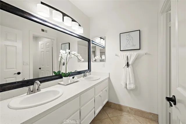 a bathroom with a double vanity sink a mirror and a shower