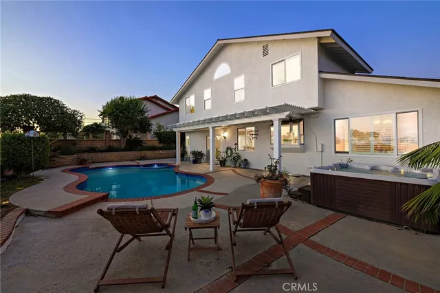 a patio with table and chairs and potted plants