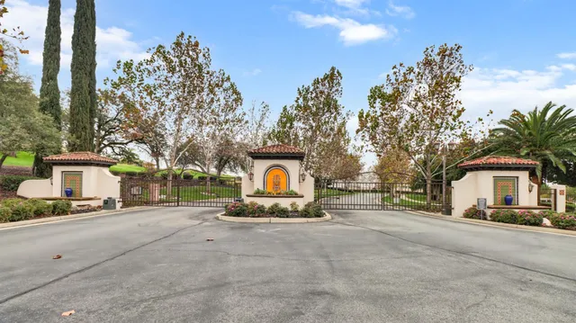a view of a house with a yard and large trees