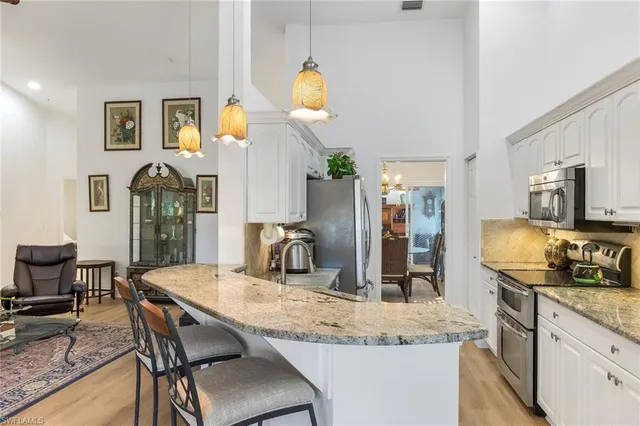 a kitchen with granite countertop a sink cabinets and stainless steel appliances