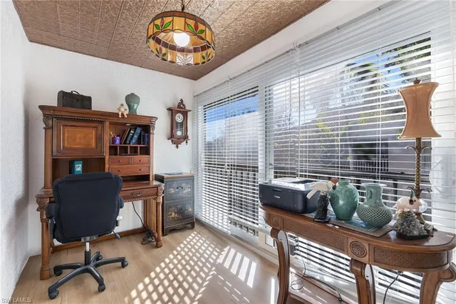 a view of a workspace with furniture and a window
