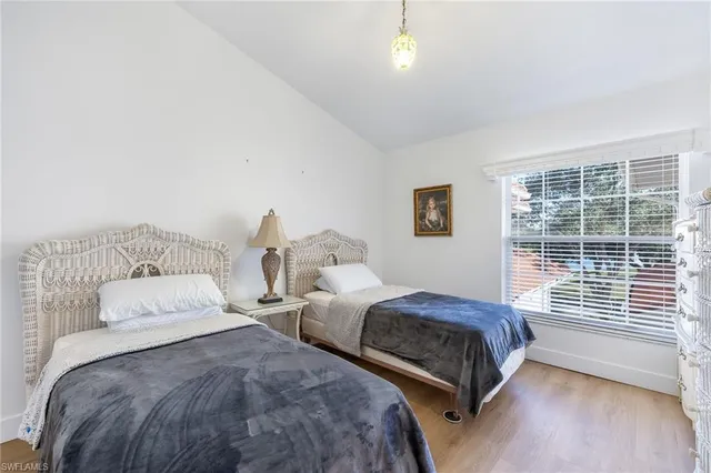 a bedroom with two beds and a large window