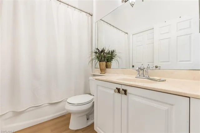 a bathroom with a granite countertop sink a toilet and a mirror