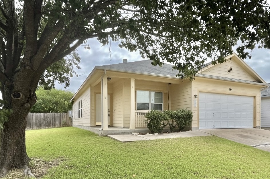 11825 Navasota Street Manor, TX 78653 - Photo 1 of 1 a front view of a house with a yard and garage